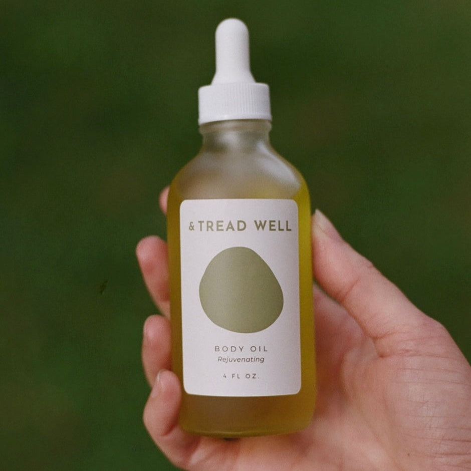 Body Oil, Organic and Non Greasy being held against a green background