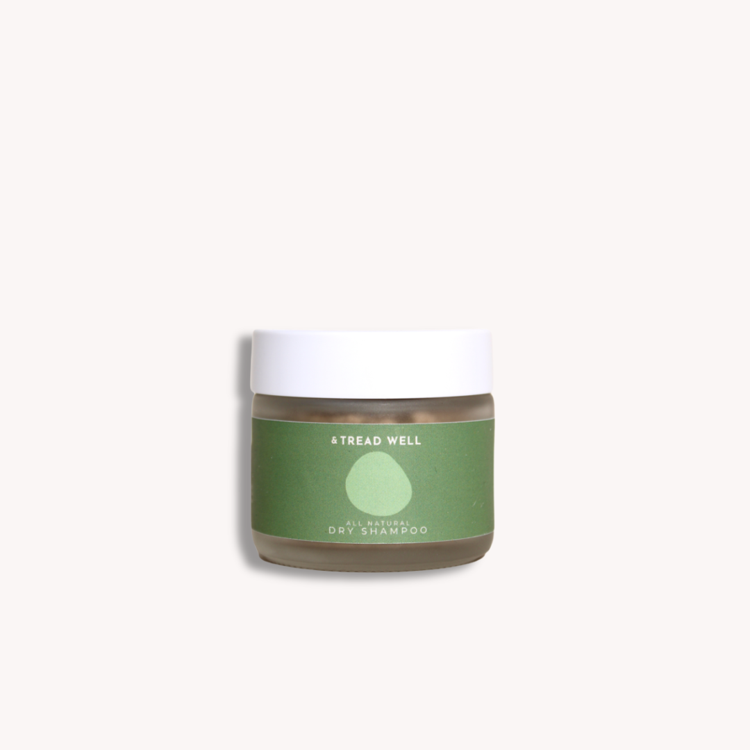Jar of dry shampoo with a green label on a white background