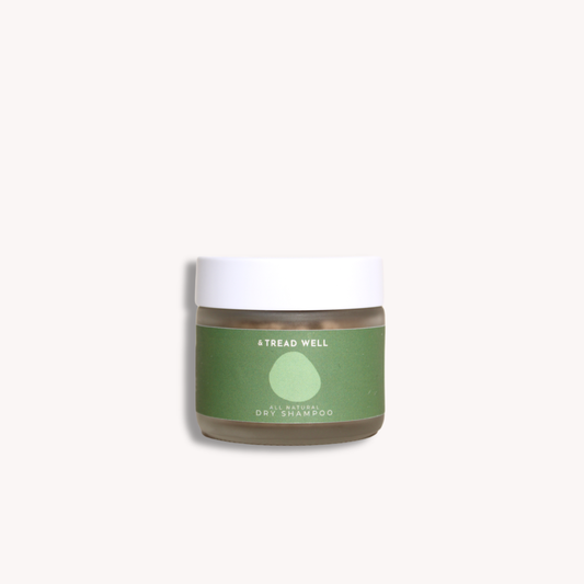 Jar of dry shampoo with a green label on a white background