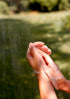 Hands with soap bubbles against a blurred natural background