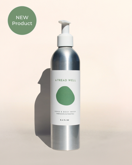 Bottle of hand and body wash with a white pump on a beige background, featuring the brand 'Tread Well'.