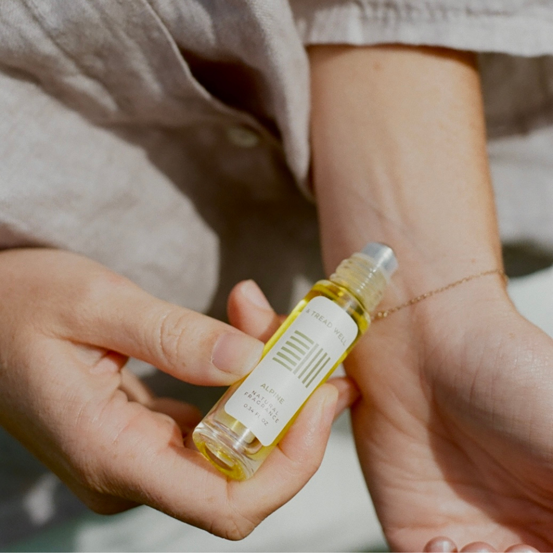 Person holding a small bottle of oil or serum with a blurred background
