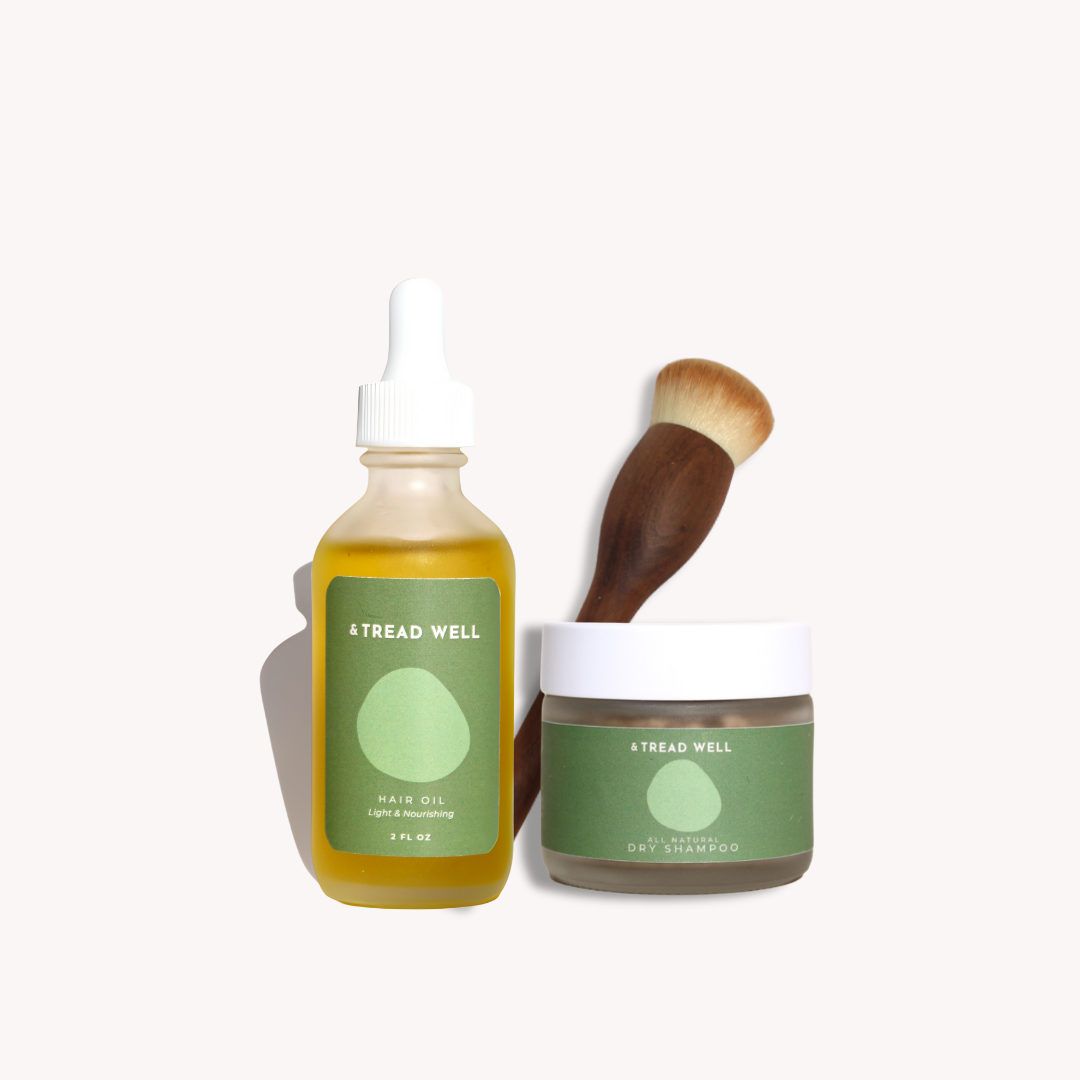 Tread Well hair care products including oil, shampoo, and brush on a white background