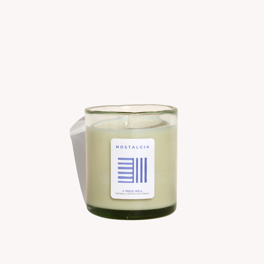 Candle in a glass jar with a label on a white background